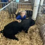 Grey Mixon with her first livestock project, a hog named Marshmallow
